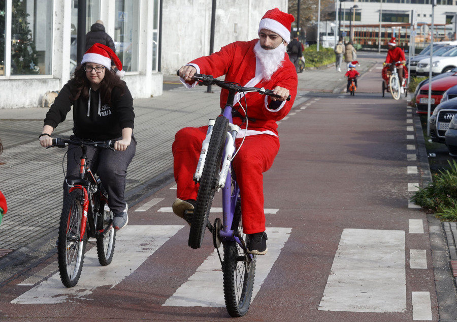 Ciclista En Sombrero De Santa Y Ropa Deportiva En El Día De Invierno .  Navidad Y Año Nuevo . Concepto De Celebración De Vacaciones . El Hombre De  Apartamentos Que Monta El