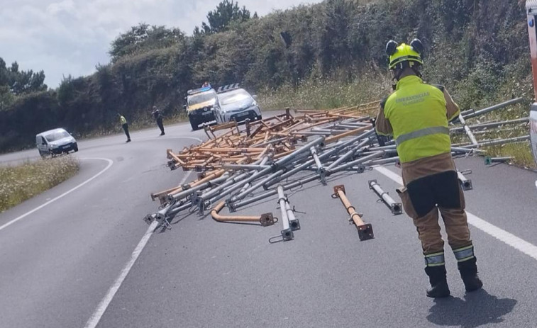 Un camión pierde su carga y deja puntales de encofrado tirados por la carretera de Bamio