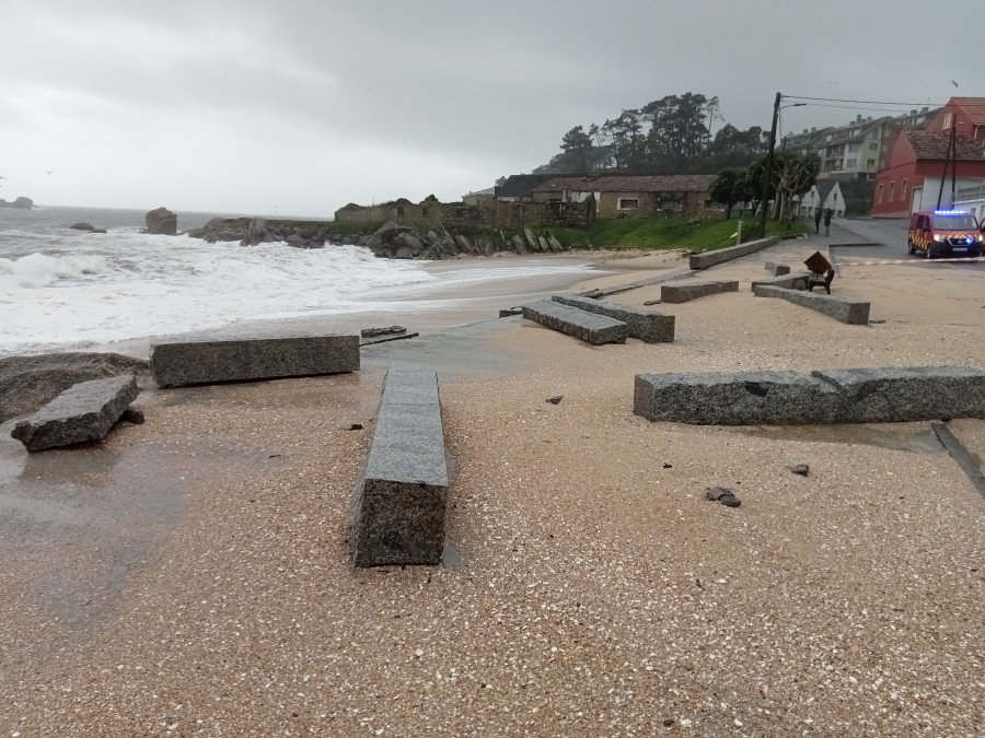 El fuerte oleaje derriba el petril que separa el paseo marítimo de la playa de Area Secada, en Ribeira