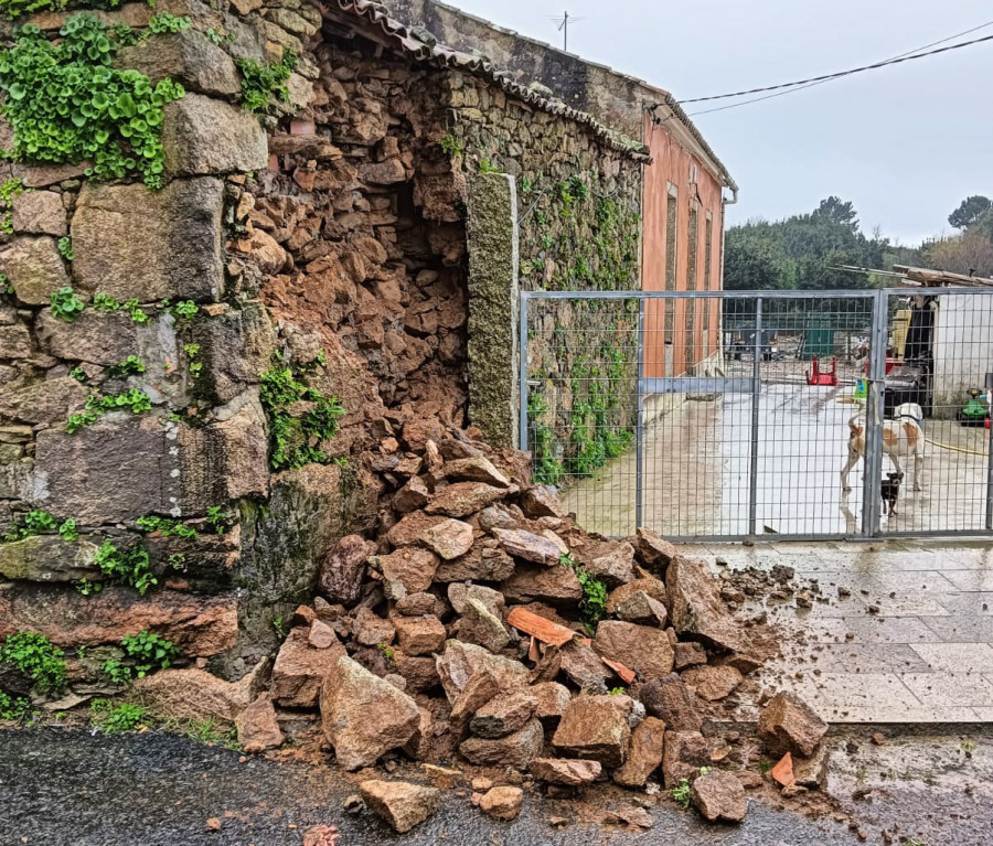 La borrasca Karlotta causa el derrumbe de un muro de una casa antigua en el lugar de Cercias, en A Pobra