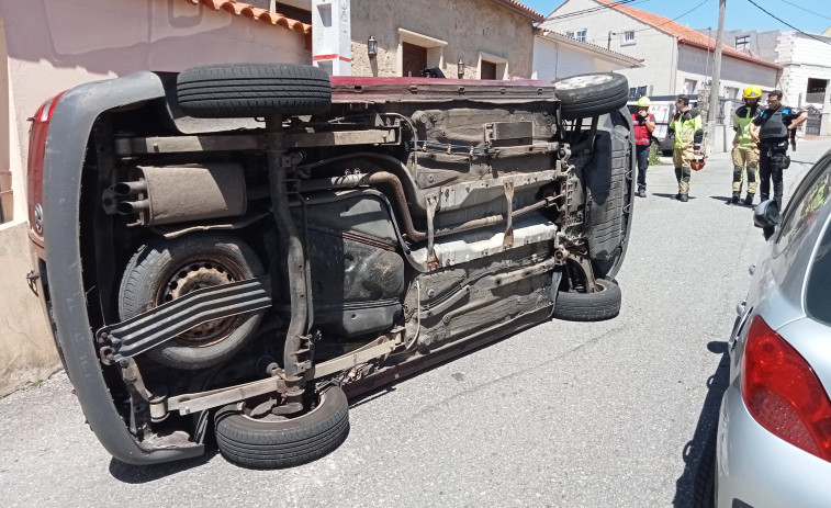 Tres vecinos rescatan a un conductor atrapado en el interior de una furgoneta volcada en Rúa dos Curros, en Castiñeiras