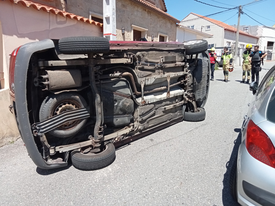 Tres vecinos rescatan a un conductor atrapado en el interior de una furgoneta volcada en Rúa dos Curros, en Castiñeiras