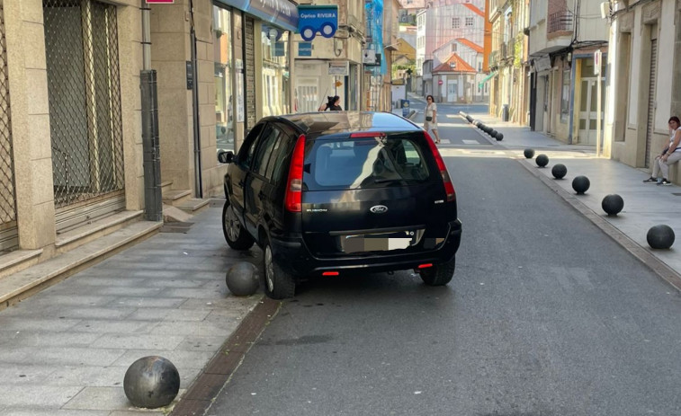 Un coche acaba subido a una bola metálica o bolardo en el casco urbano de Ribeira