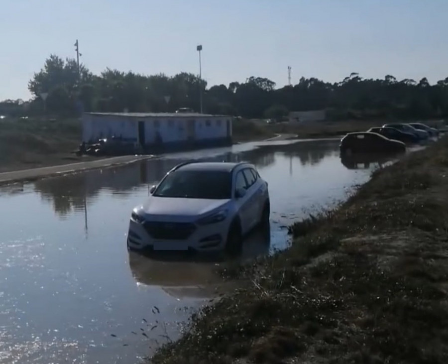 La marea alcanza varios vehículos aparcados en el litoral de A Illa