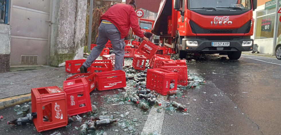 Un camión de reparto derrama gran parte de su carga de botellas de refrescos en un céntrico vial de Ribeira