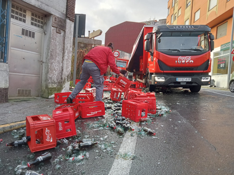 Un camión de reparto derrama gran parte de su carga de botellas de refrescos en un céntrico vial de Ribeira