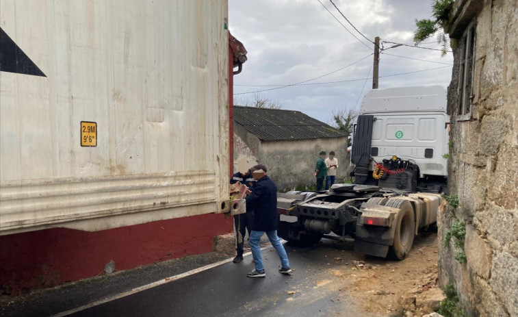 Un tráiler guiado erróneamente por el GPS queda atrapado en Deán Grande y derriba una casa