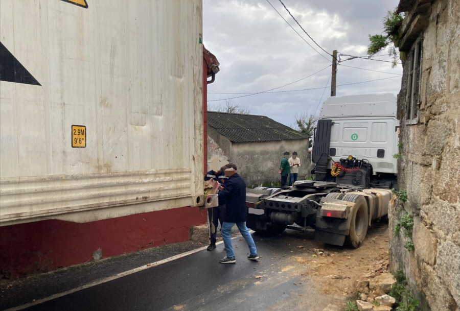 Un tráiler guiado erróneamente por el GPS queda atrapado en Deán Grande y derriba una casa