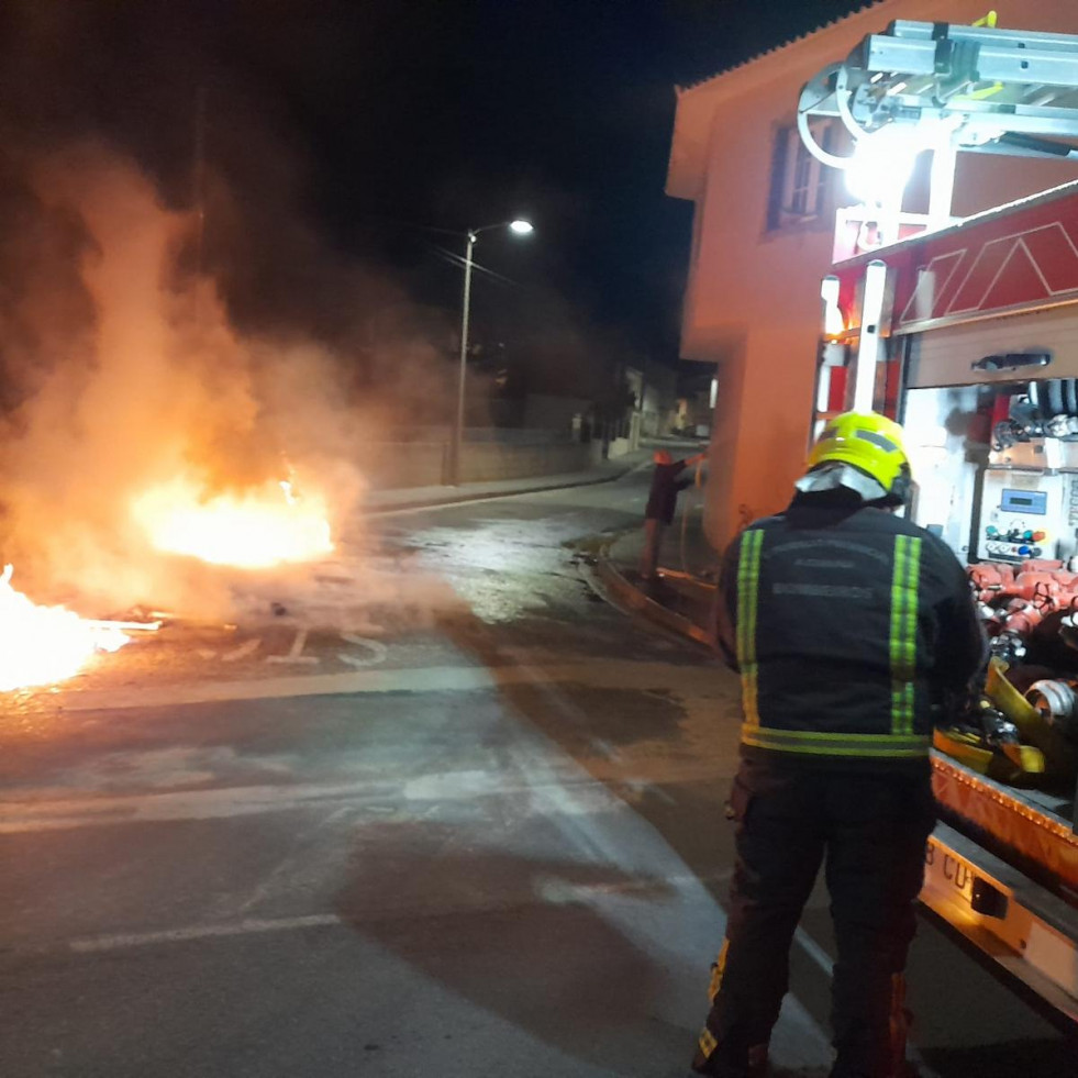 Un incendio calcina de noche cuatro contenedores de basura y afecta a un muro y la fachada de una vivienda en Aguiño